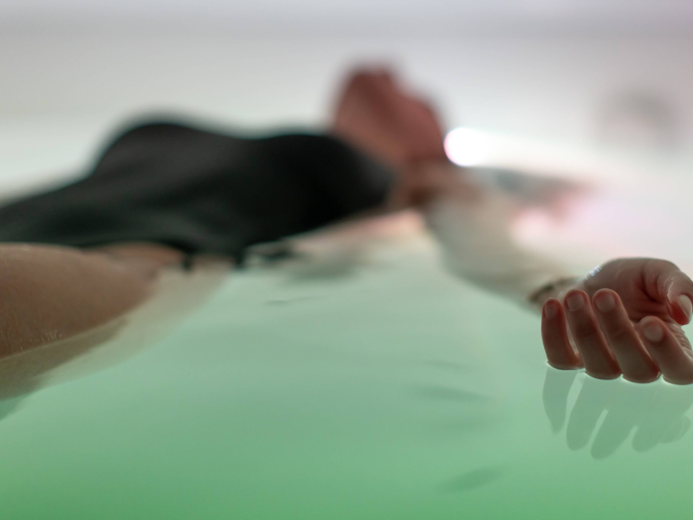 Jeune femme entrain de flotter dans un caisson de flottaison en isolation sensorielle chez Cocon
